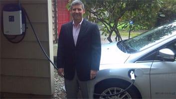 Photo of Matthew D. Dubin with his electric car